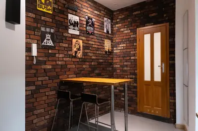 a brick wall with a table and two chairs at Soniya's Castle View Apartment in Kraków