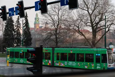 a green bus driving down a city street at Soniya's Castle View Apartment in Kraków