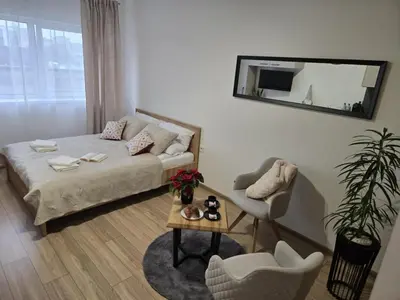 a living room with a bed and a table and a mirror at Kobierzyńska Apartments in Kraków