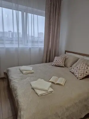 a bed with towels and books on it with a window at Kobierzyńska Apartments in Kraków