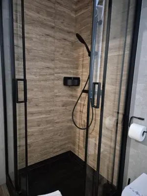 a shower with a glass door in a bathroom at Kobierzyńska Apartments in Kraków