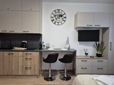 a kitchen with two bar stools and a counter at Kobierzyńska Apartments in Kraków