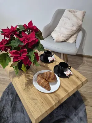 a table with a plate of croissants and two cups of coffee at Kobierzyńska Apartments in Kraków