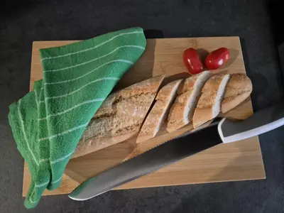 a cutting board with a knife and a loaf of fish and vegetables at Kobierzyńska Apartments in Kraków