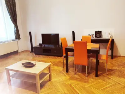 a dining room with a table and chairs and a television at Central Krak Apartments in Kraków