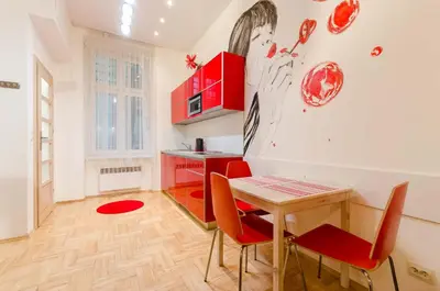 a kitchen with a table and red chairs in a room at Central Krak Apartments in Kraków