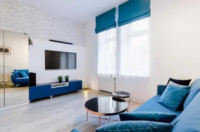 a living room with a blue couch and a table at Central Krak Apartments in Kraków