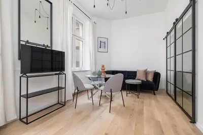 a living room with a black couch and a table at Apartment for two - Krowoderska 21 street in Kraków