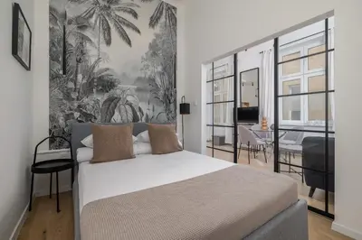 a bedroom with a large bed with a tropical wallpaper at Apartment for two - Krowoderska 21 street in Kraków