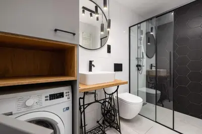 a bathroom with a washing machine and a sink at Apartment for two - Krowoderska 21 street in Kraków