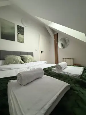 a room with two beds with towels on them at MICKIEWICZ HOUSE Apartamenty in Wadowice