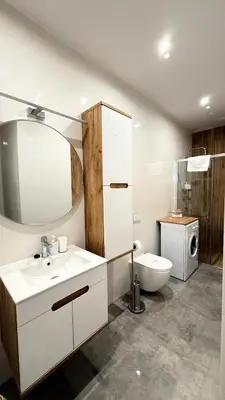 a bathroom with a sink and a toilet and a mirror at MICKIEWICZ HOUSE Apartamenty in Wadowice