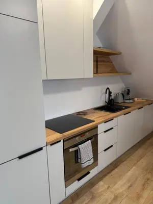 a kitchen with white cabinets and a stove top oven at MICKIEWICZ HOUSE Apartamenty in Wadowice