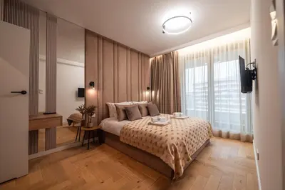 a bedroom with a bed and a large window at Clermont Apartment by Cracovia Prime in Kraków