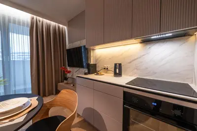 a kitchen with a sink and a stove and a table at Clermont Apartment by Cracovia Prime in Kraków