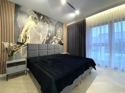 a bedroom with a large bed and a painting on the wall at Apartament przy Rakowickiej IV Old Town in Kraków
