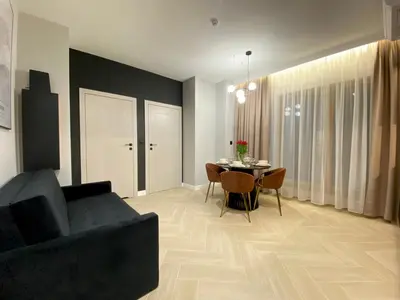 a living room with a black couch and a table at Apartament przy Rakowickiej IV Old Town in Kraków