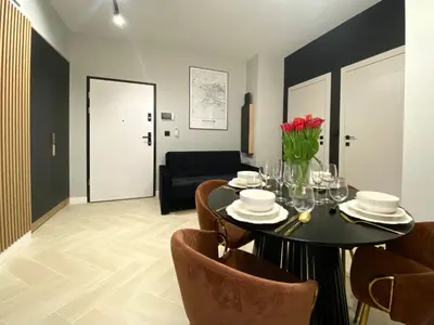 a dining room with a black table and chairs at Apartament przy Rakowickiej IV Old Town in Kraków