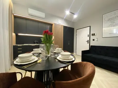 a dining room table with a vase of flowers on it at Apartament przy Rakowickiej IV Old Town in Kraków
