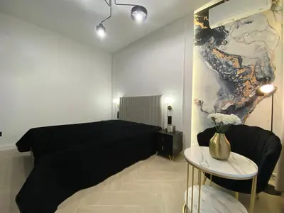a bedroom with a black bed and a table at Apartament przy Rakowickiej I Old Town in Kraków