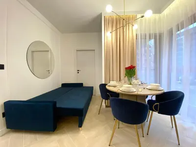 a living room with a table and a blue couch at Apartament przy Rakowickiej I Old Town in Kraków