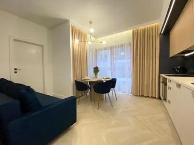 a living room with a blue couch and a table at Apartament przy Rakowickiej I Old Town in Kraków