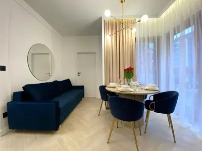 a living room with a blue couch and a table at Apartament przy Rakowickiej I Old Town in Kraków