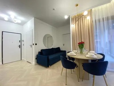 a living room with a table and a blue couch at Apartament przy Rakowickiej I Old Town in Kraków