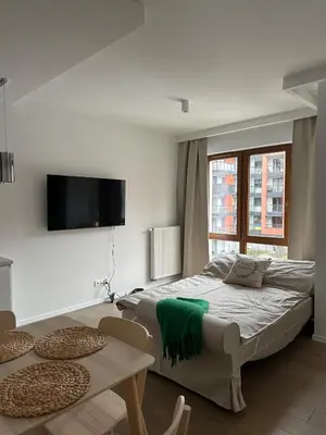 a bedroom with a bed and a table and a tv at Art Studio Rakowicka in Kraków