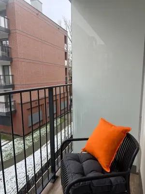 a black chair with an orange pillow on a balcony at Art Studio Rakowicka in Kraków