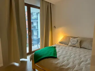a bedroom with a bed and a large window at Art Studio Rakowicka in Kraków