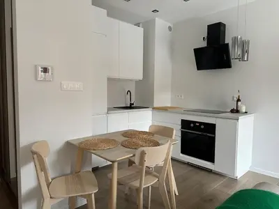 a kitchen with a table and chairs and a kitchen with white cabinets at Art Studio Rakowicka in Kraków