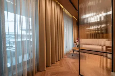 a hallway with curtains and a room with a table at Fleurmont Apartment by Cracovia Prime in Kraków