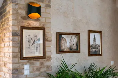 a group of pictures hanging on a brick wall at Krzyża Residence in Kraków