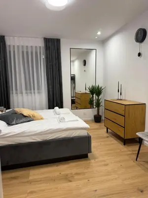 a bedroom with a bed and a dresser and a mirror at MICKIEWICZ HOUSE Apartamenty in Wadowice