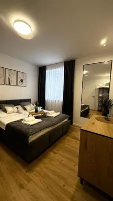 a bedroom with a large bed and a large mirror at MICKIEWICZ HOUSE Apartamenty in Wadowice
