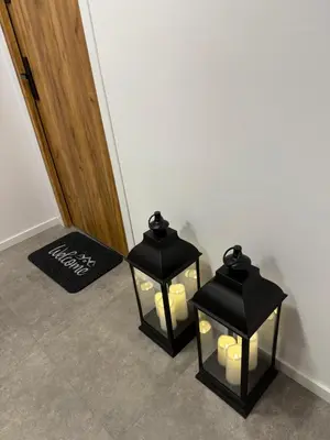 two black lanterns with candles in a hallway at MICKIEWICZ HOUSE Apartamenty in Wadowice