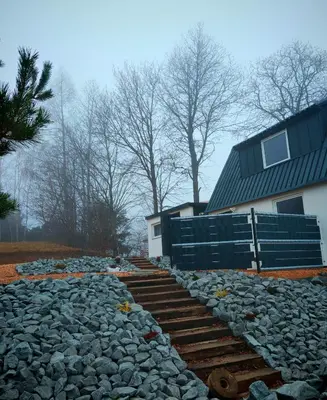 a stone walkway next to a building with a house at Beskidzka Oaza 2 in Targanice