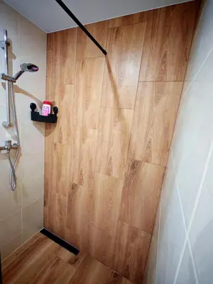 a shower in a bathroom with a wooden floor at Beskidzka Oaza 2 in Targanice
