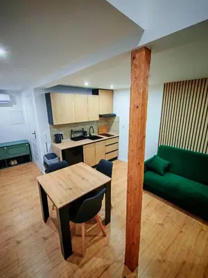a kitchen with a wooden table and a green couch at Beskidzka Oaza 2 in Targanice