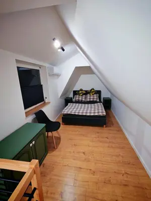 a attic room with a bed and a television at Beskidzka Oaza 2 in Targanice