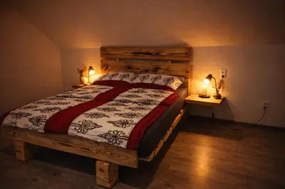 a bedroom with a bed with a wooden headboard at Pod Łopieniem z Sauną i Balią in Tymbark