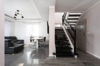 a living room with a staircase and a couch at Pod Łopieniem z Sauną i Balią in Tymbark