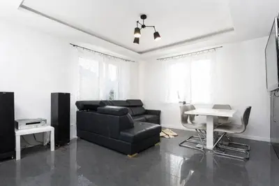 a living room with a black couch and a table at Pod Łopieniem z Sauną i Balią in Tymbark