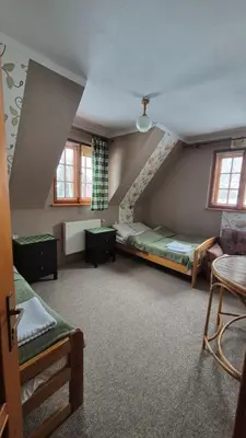 a attic room with a bed and a staircase at Dom na Leśnej - Mszana Dolna in Mszana Dolna