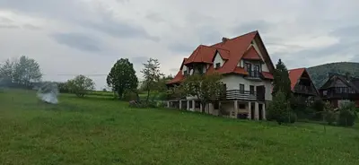 a large house on a hill in a field at Dom na Leśnej - Mszana Dolna in Mszana Dolna