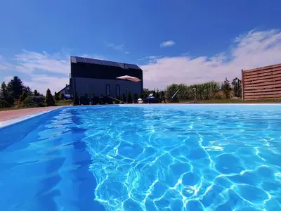 a large pool of blue water in front of a building at Green Garden Zielonki 14e in Bibice