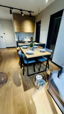 a dining room with a table and chairs in a room at Green Garden Zielonki 14e in Bibice