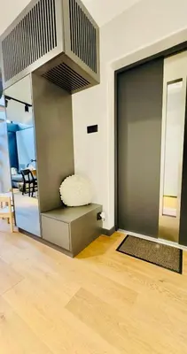 a living room with a large door with a chair at Green Garden Zielonki 14d in Bibice