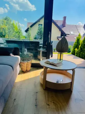a living room with a table and a couch at Green Garden Zielonki 14d in Bibice